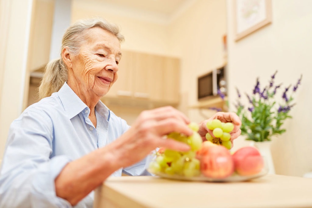 Elderly woman looking at fruit