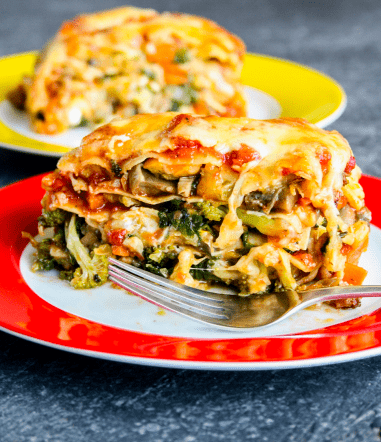 An image of veggie lasagna on a plate with a fork.