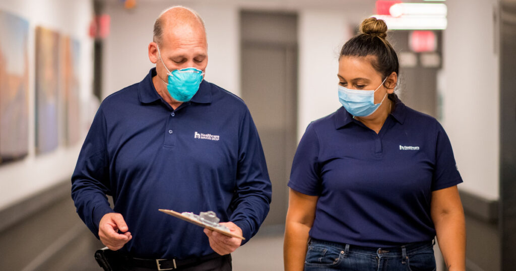 Two HCSG employees walking down a facility hallway