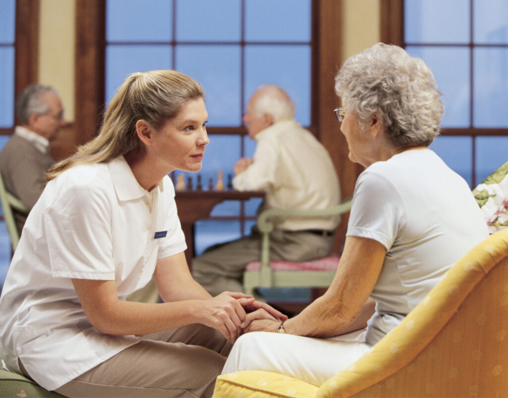 Woman sitting with geriatric resident