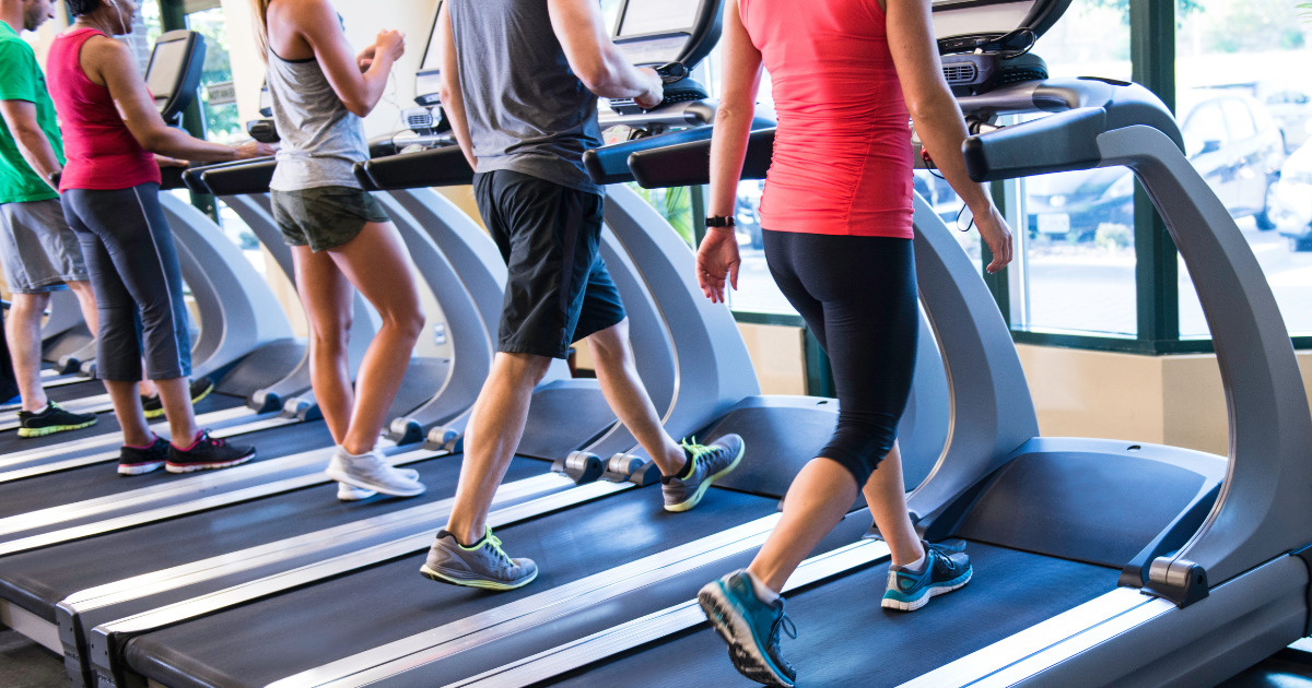 People jogging on treadmills in a gym.