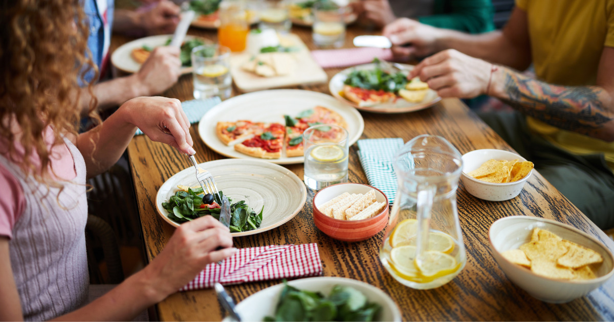 People gathered around a table eating food.