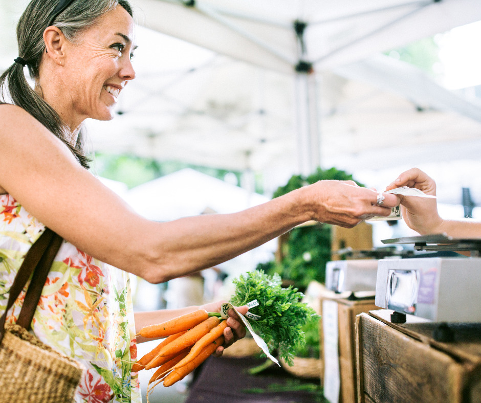 Woman using cash at farmers' market.