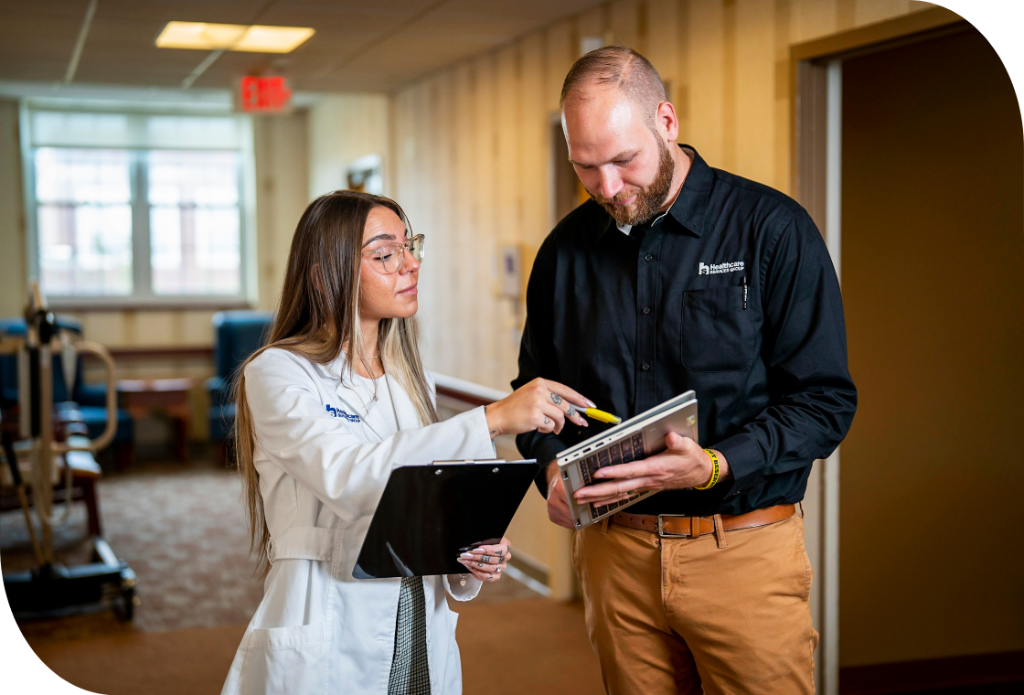 Smiling caregiver warmly interacts with a senior woman in a healthcare setting. Compassionate care and positive engagement in a senior living community.