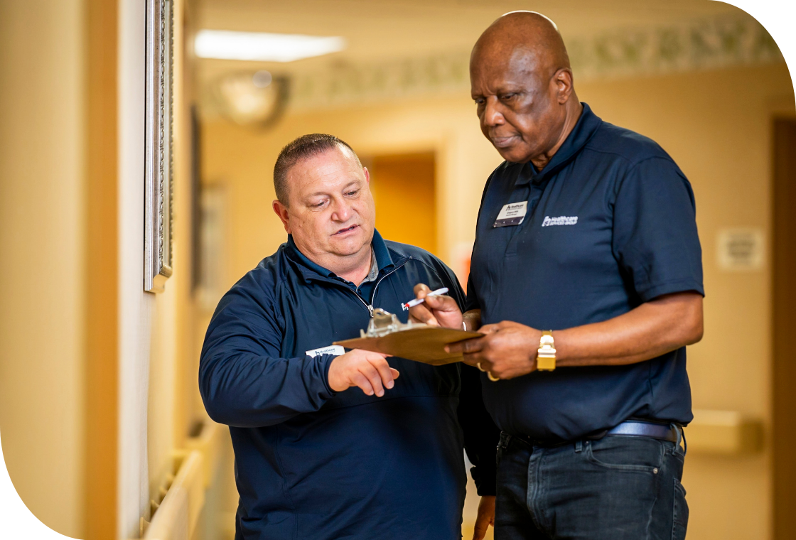 Smiling caregiver warmly interacts with a senior woman in a healthcare setting. Compassionate care and positive engagement in a senior living community.